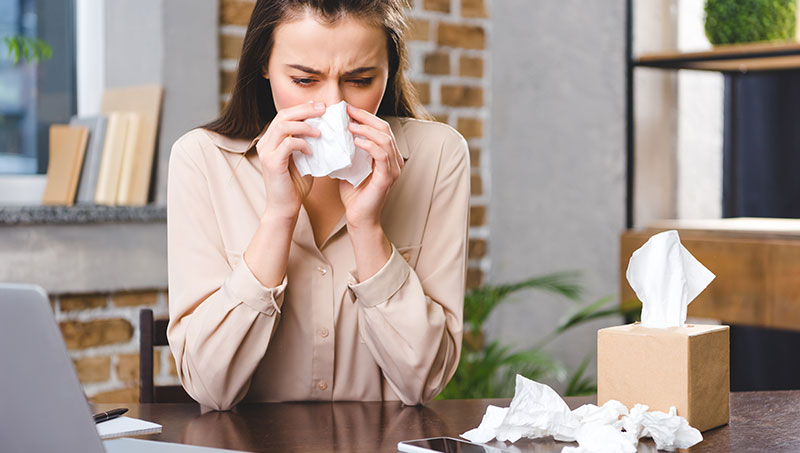 Woman with allergies researching chiropractic care for allergy relief