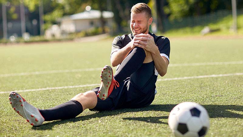 Male soccer player in pain with knee injury